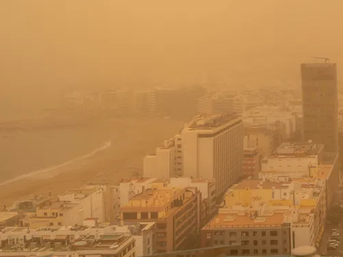 Las Palmas de Gran Canaria during a Calima - Playa de Las Canteras and the city behind a dense orange haze of Saharan dust