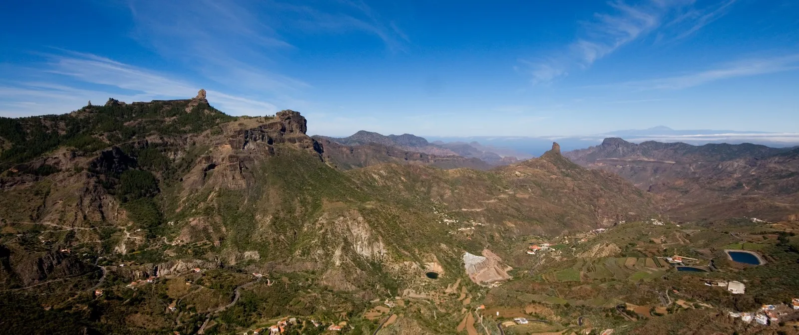 Panorama of the caldera around Tejeda: terraced slopes, scattered white houses and bare rock walls under a deep blue sky