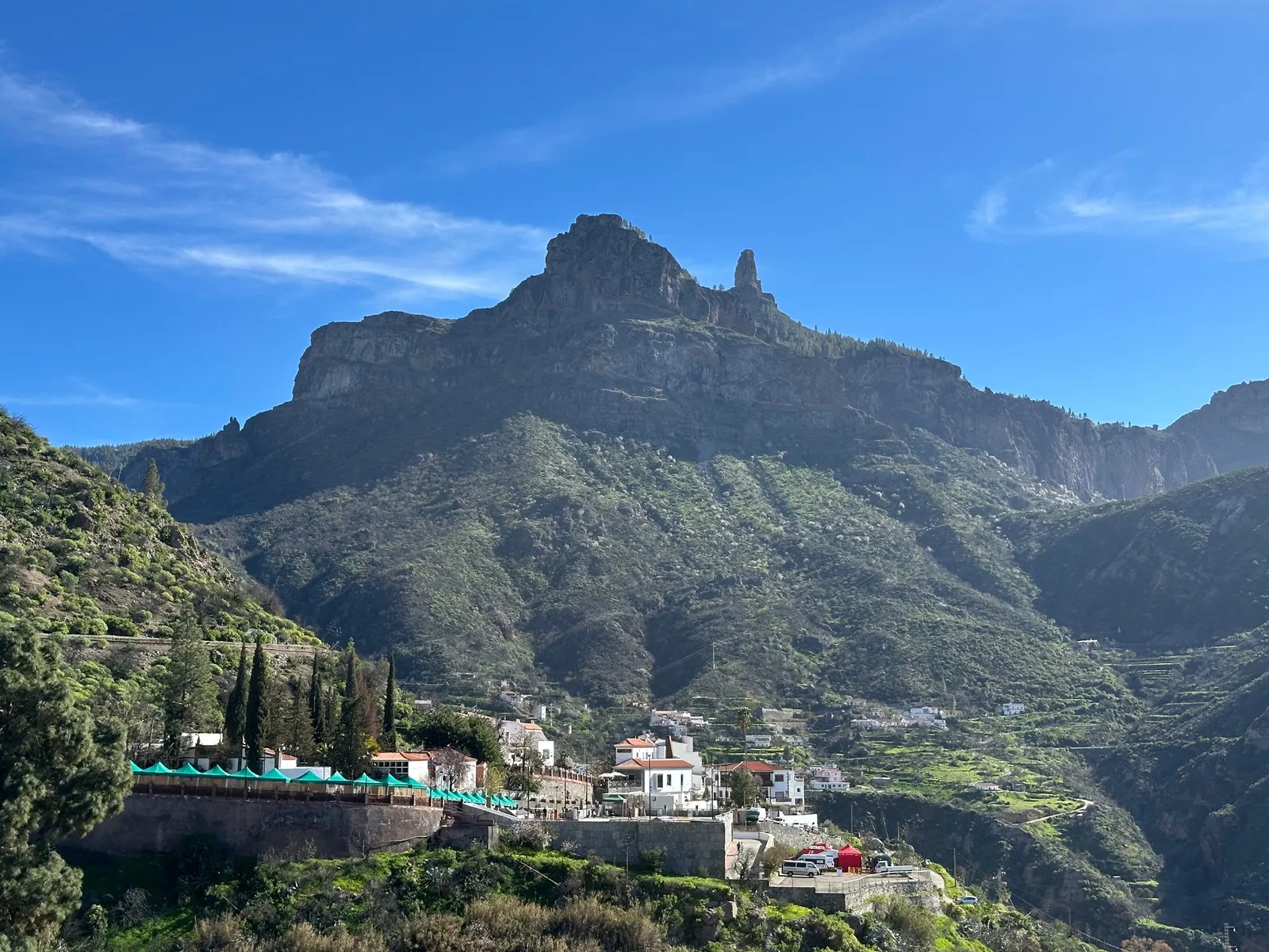 The white houses of Tejeda on the floor of the crater, with the rock needle of Roque Nublo on the ridge above them