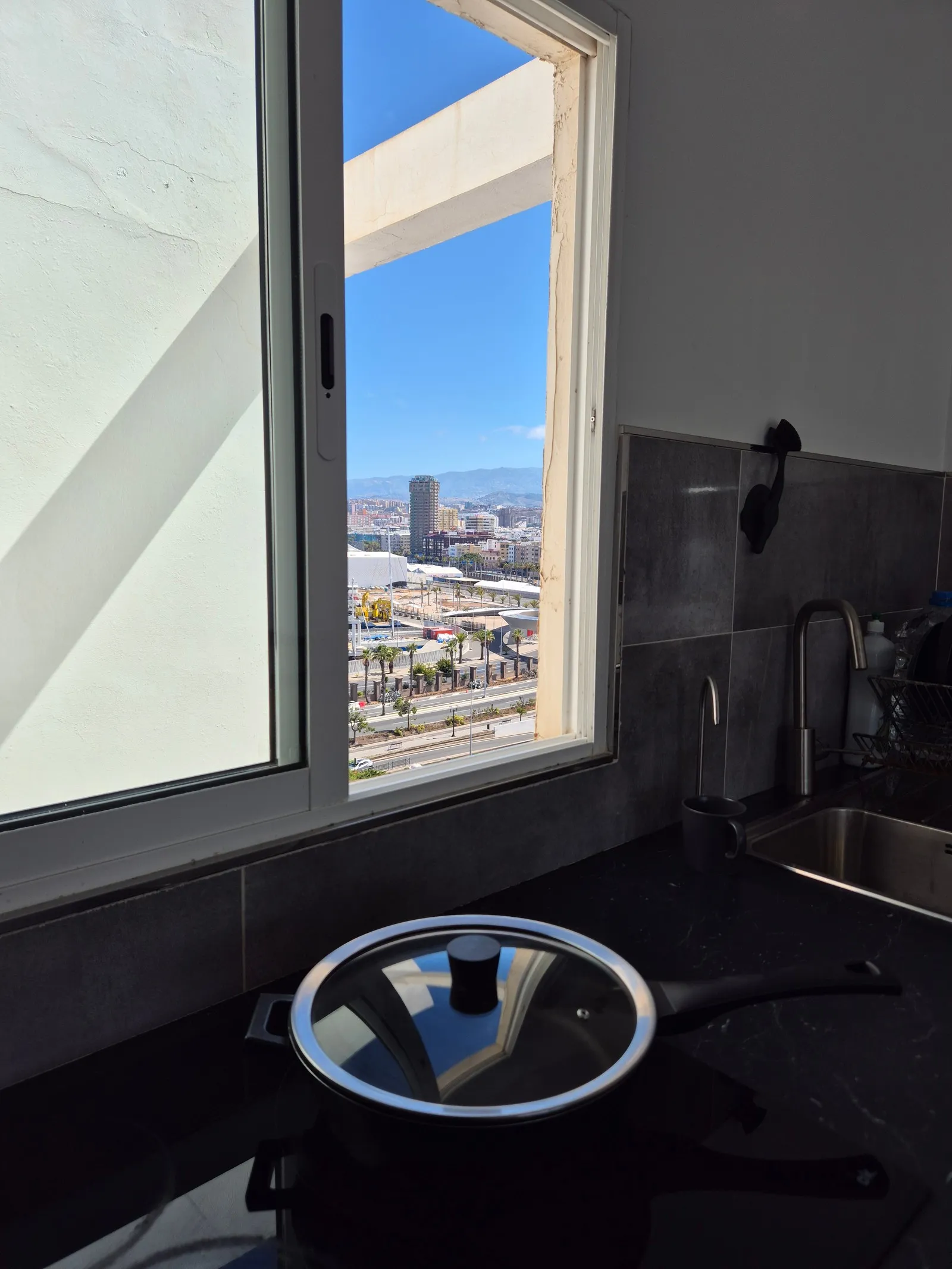 Kitchen and living room at J48 Penthouse - stove, view from the kitchen, blue sky