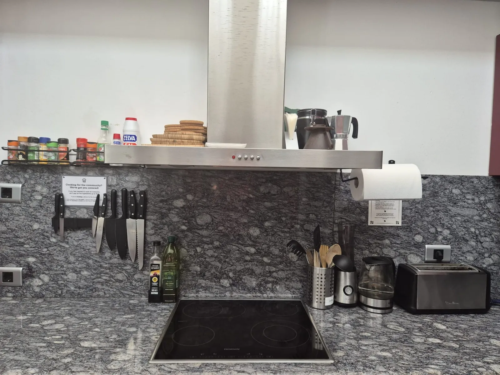 The kitchen work area at U32: spice rack, magnetic knife strip, induction hob, kettle, blender, toaster and a kitchen paper holder