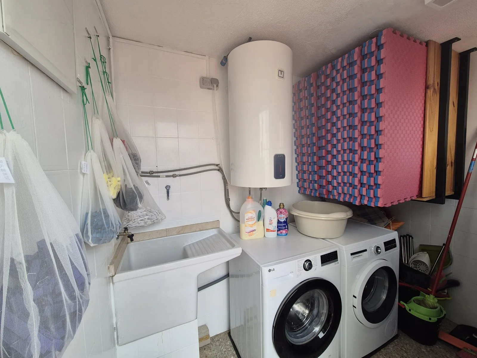 The laundry and tatami room at U32: two washing machines, tatami mats, clothes pegs in your room colour, the 100 l boiler and the detergent