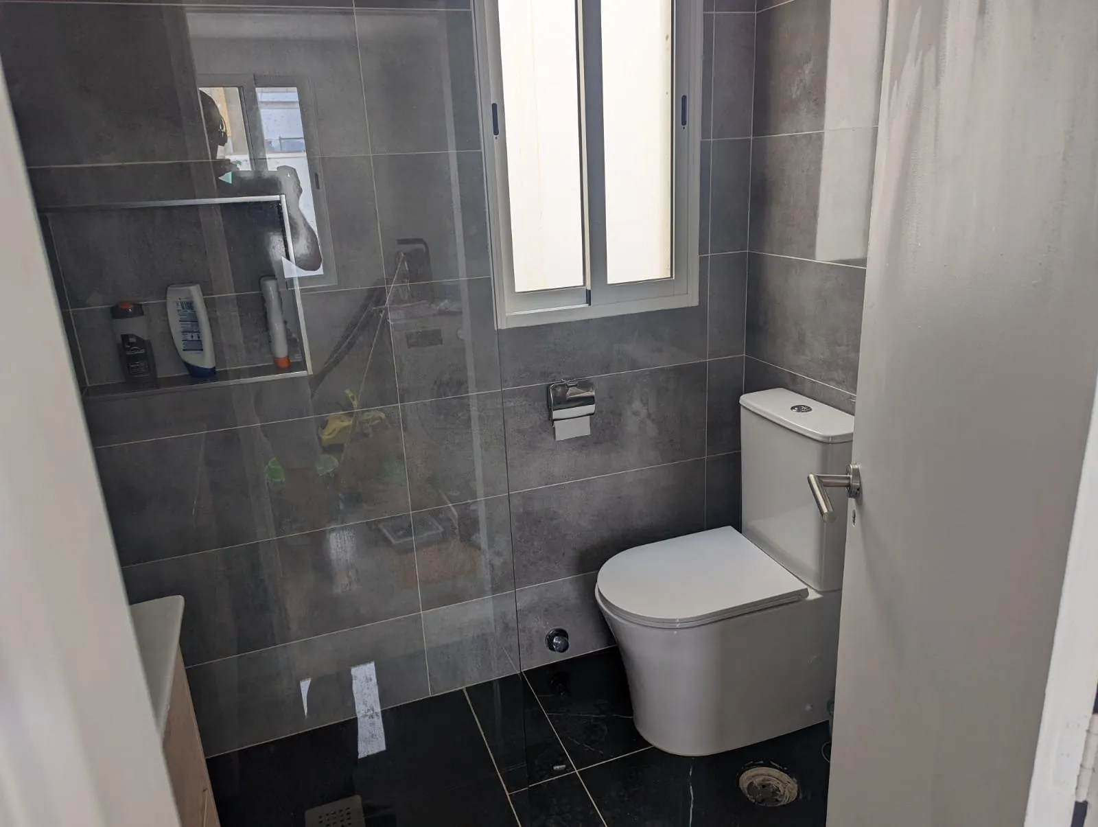 Main bathroom at J48 Penthouse - shower, toilet, window to the patio