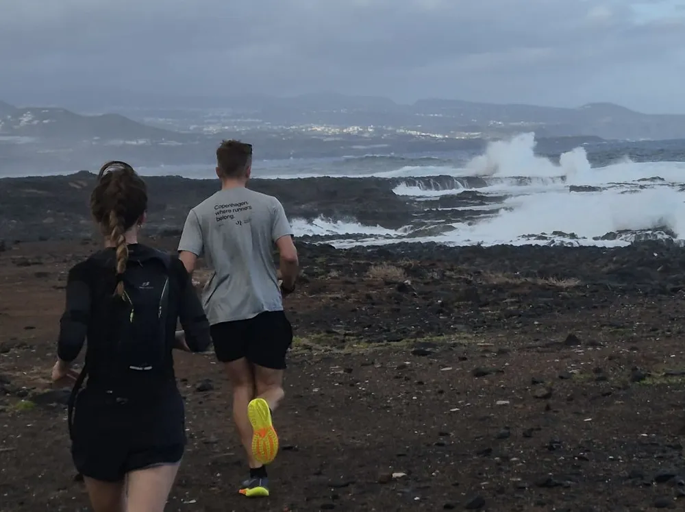Two runners on the volcanic trail above Playa de Confital, Las Palmas de Gran Canaria