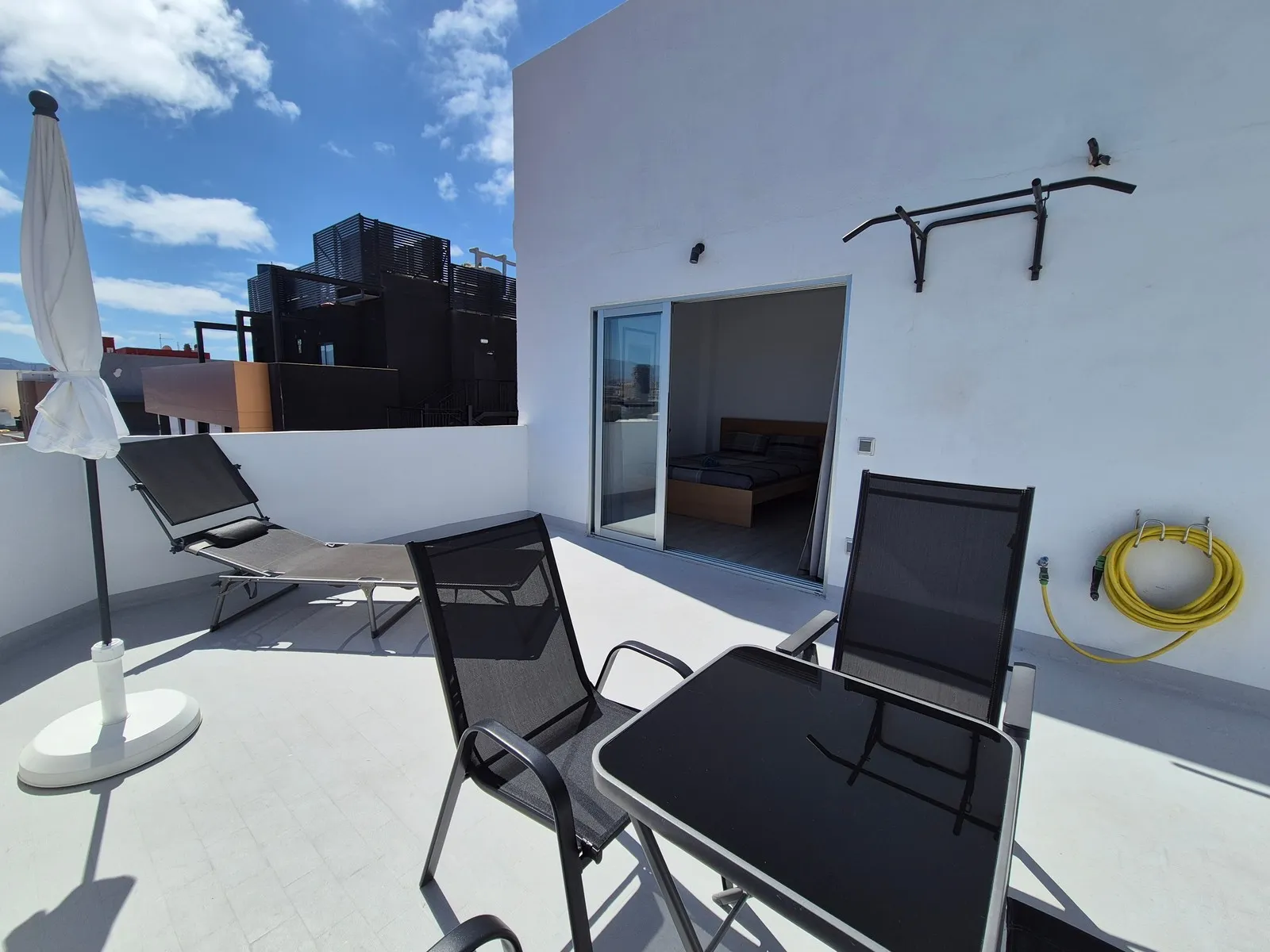 Southern terrace at Highline Haven - parasol, sunbed, pull-up bar, blue sky