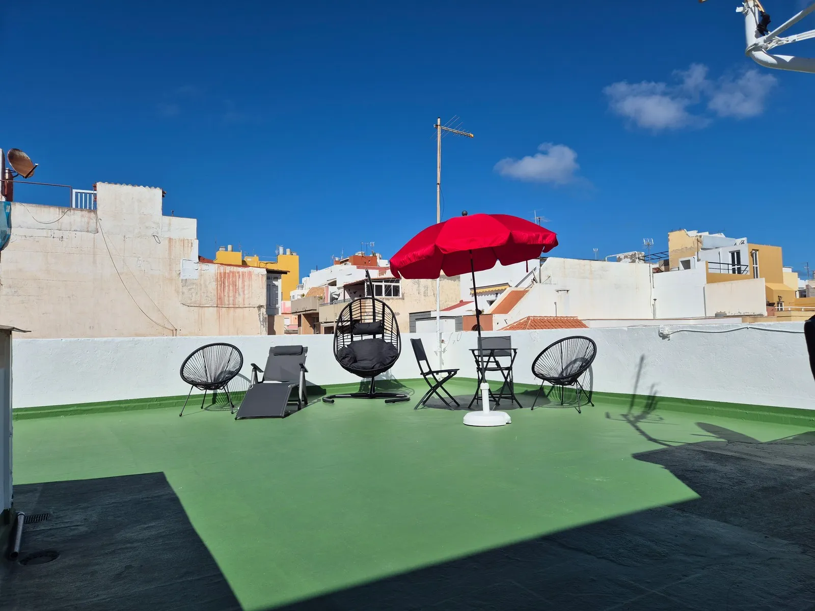 Sunbathing terrace at P21 Outpost - blue sky, parasol, hanging chair