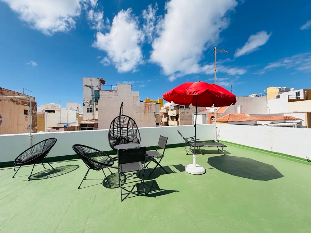 Sunbathing terrace at P21 Outpost - hanging chair, blue sky, parasol, sunbed