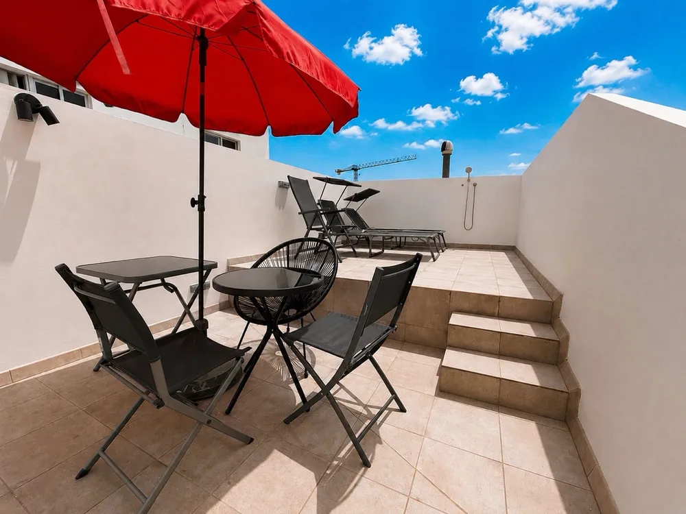 Sunbathing terrace at U32 Headquarter - blue sky, parasol, sunbeds, working corner