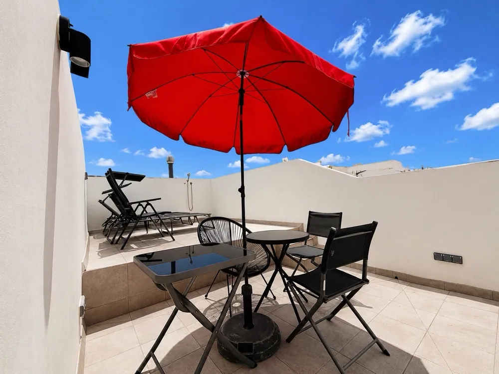 Sunbathing terrace at U32 Headquarter - parasol, blue sky, sunbed, power sockets